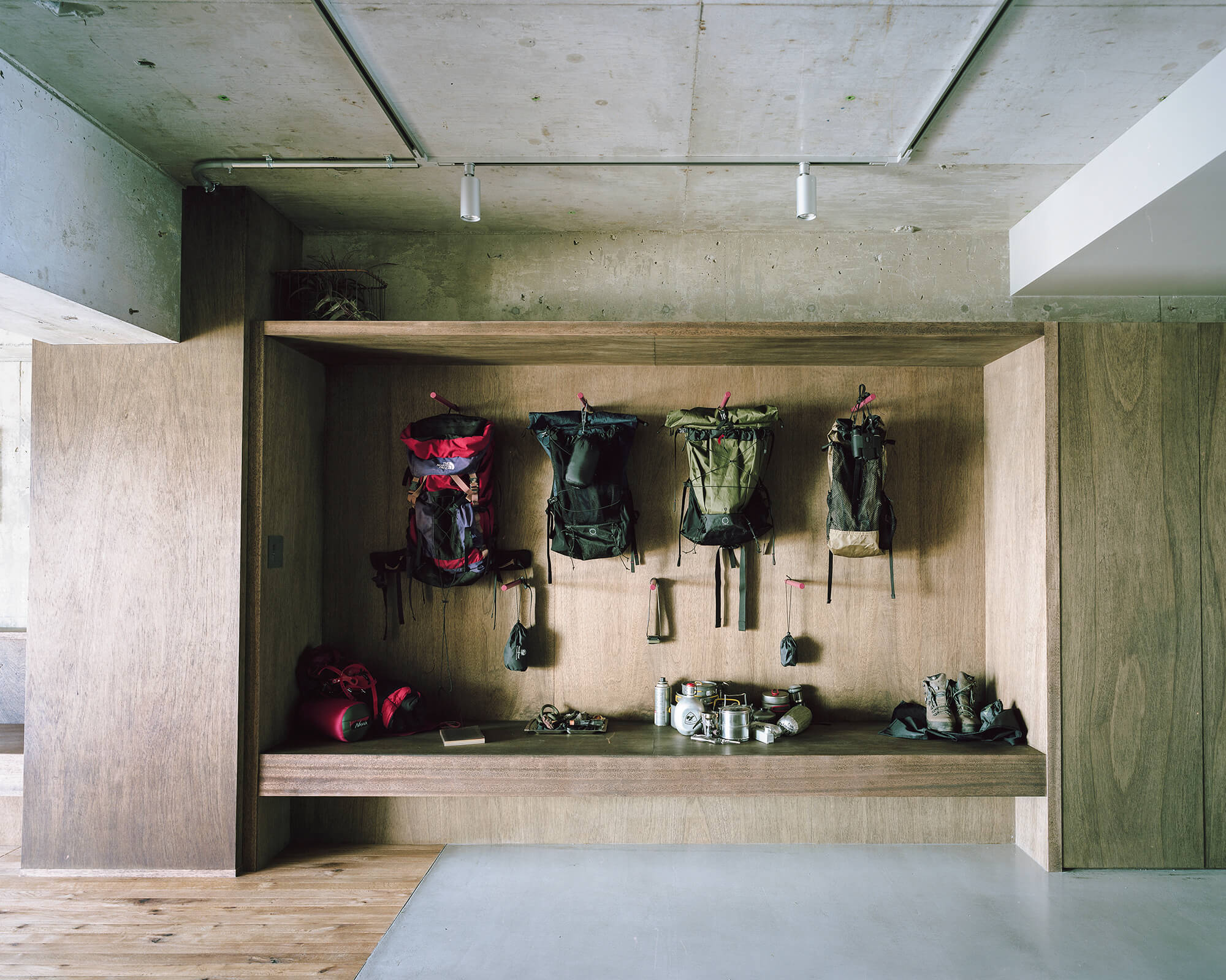 packing houseの壁に並べられたバックパックと山道具